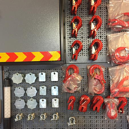 voorraad met kettingen, haken, spanners aan de muur in de werkplaats van Hooijmeijer